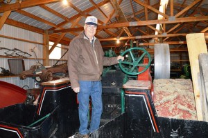 In a shop full of antique farm machinery, Dick Tombrink stands at the wheel of a Case steam engine he plans to bring to this year's 27th annual threshing bee, which features  Oliver tractors and machinery. (Judy Killen photo) 